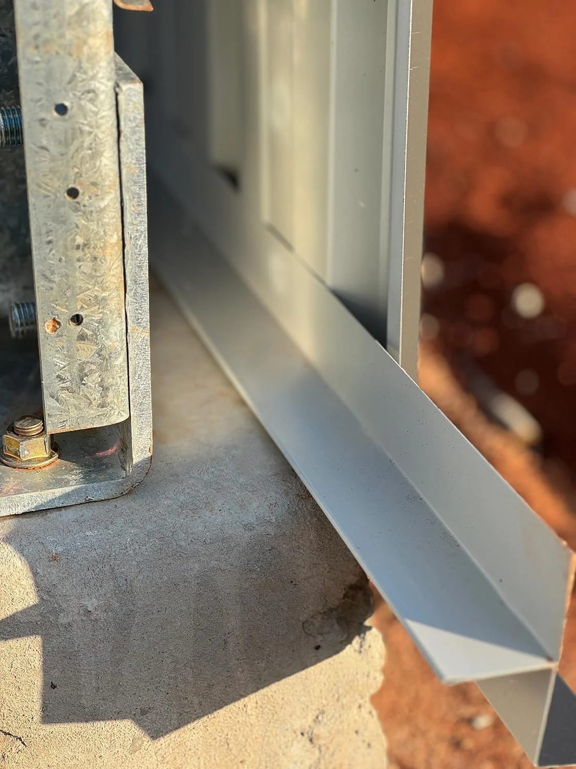 Close-up of NEVER-PEST steel flashing eliminating the gap at the base of a shed wall